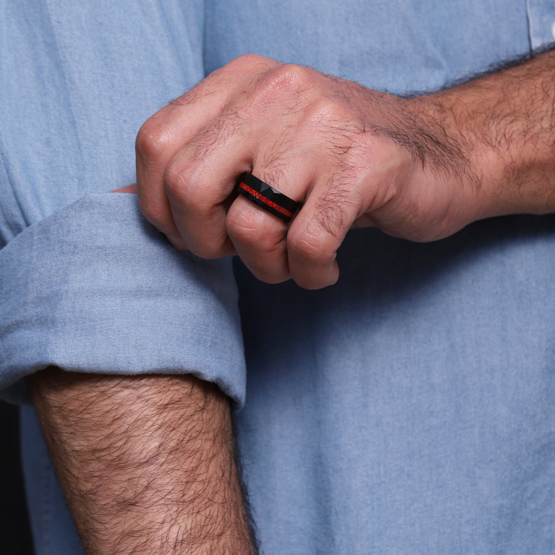 Bold and stylish men's black tungsten ring with a unique red opal inlay, accentuated by a hammered texture