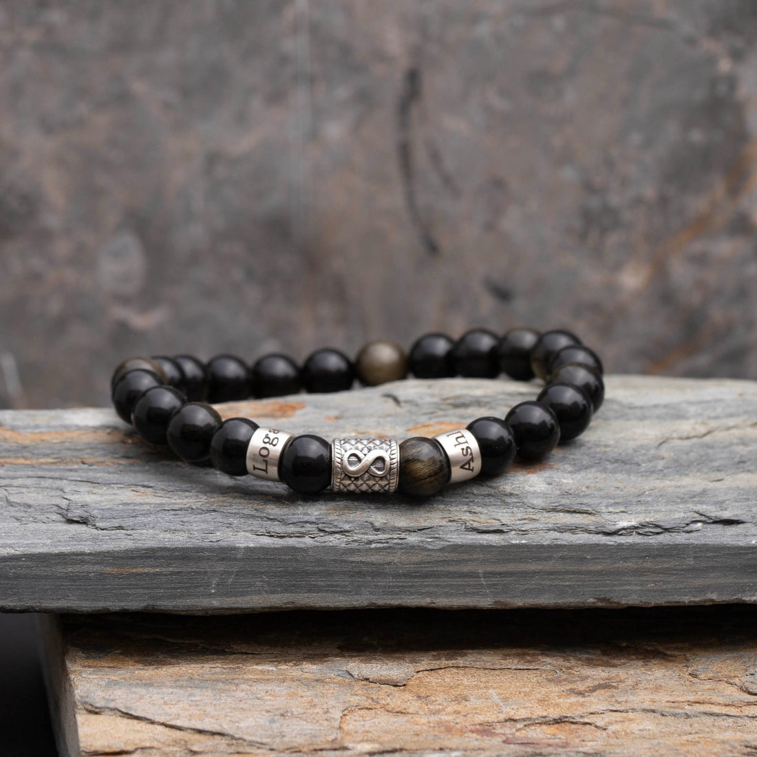 Black obsidian bead bracelet featuring engraved names and a silver infinity charm, expressing everlasting love and friendship