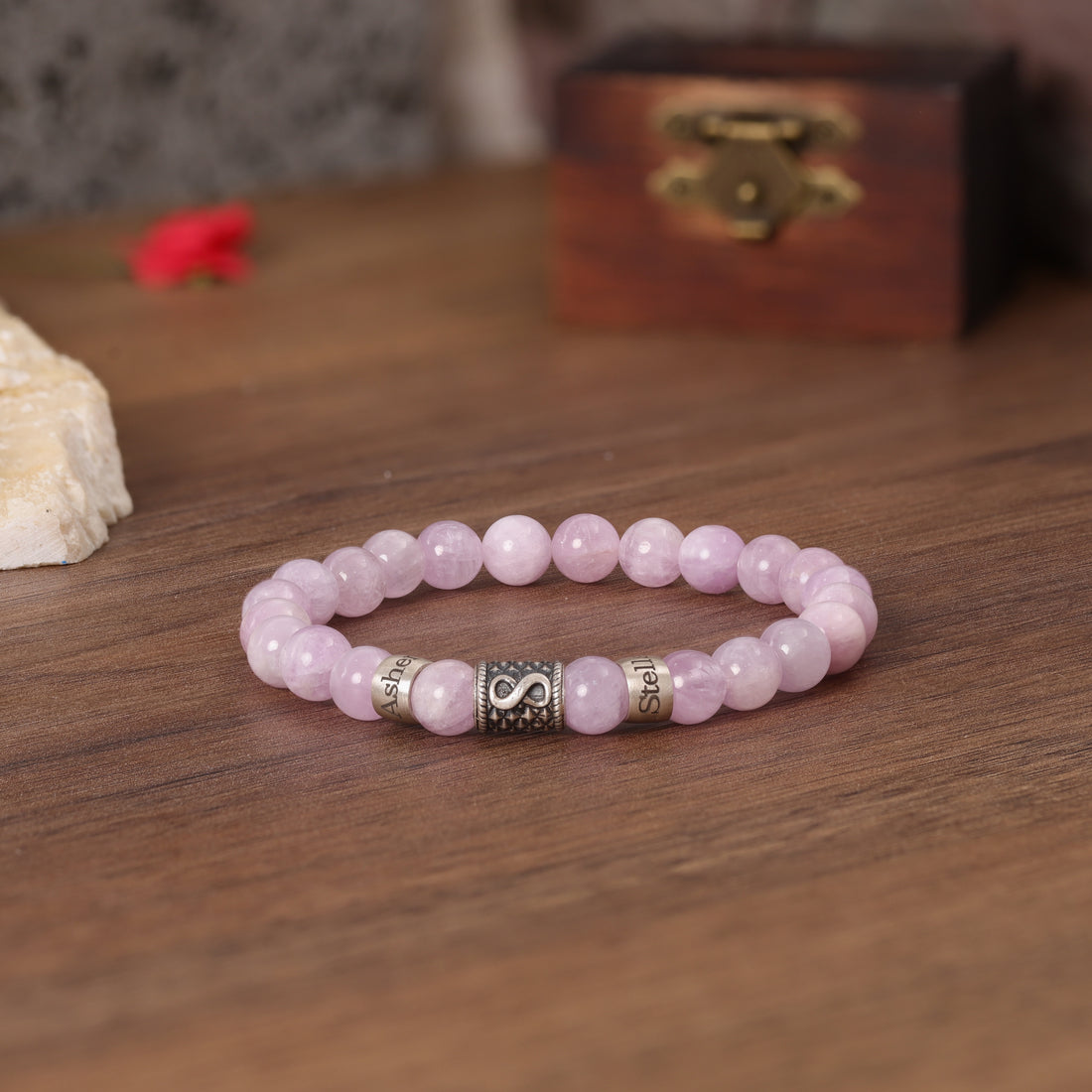 Pink quartz bracelet featuring an Infinity charm, personalized with loved ones' names.