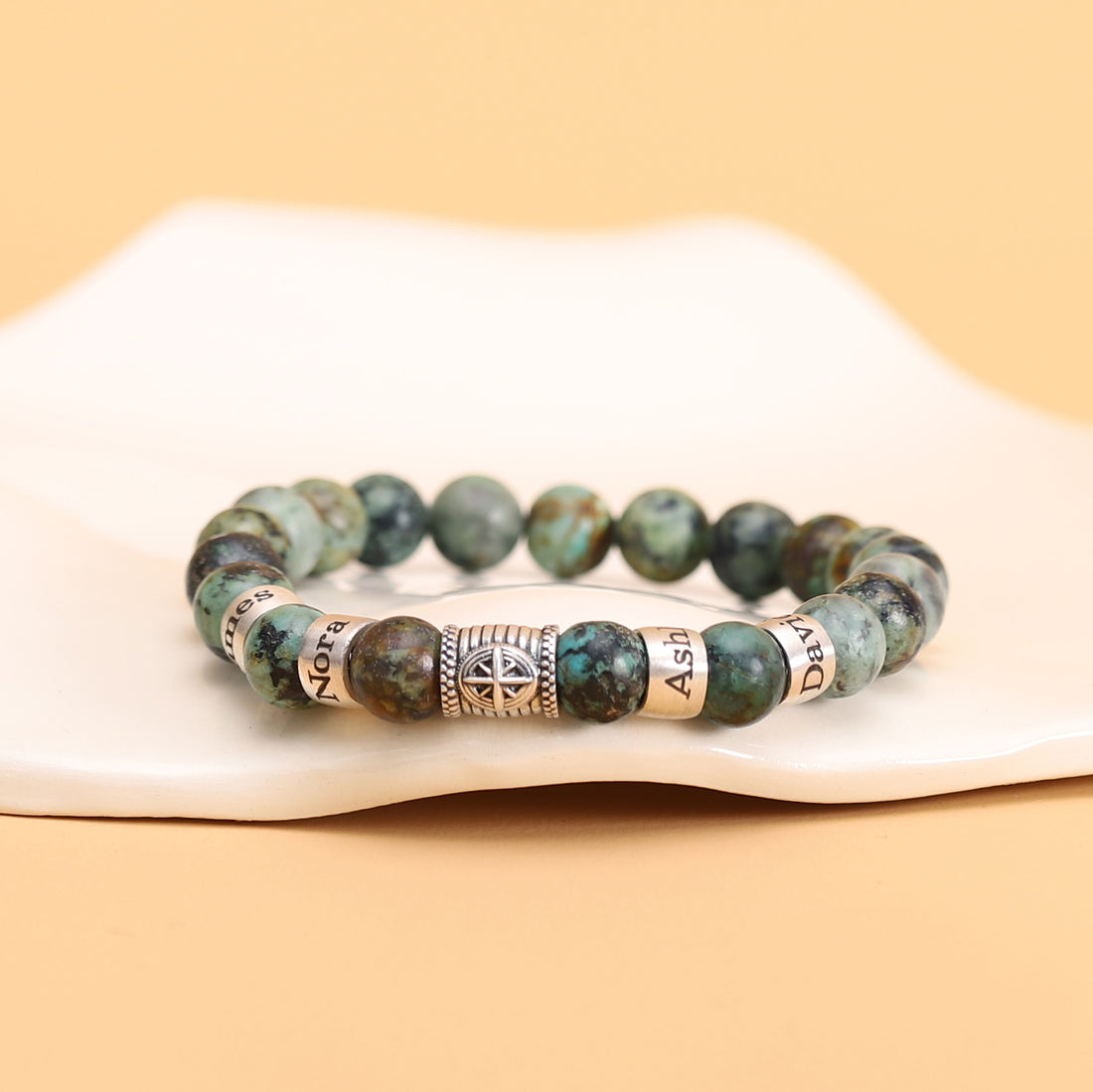 Turquoise beaded bracelet with a silver compass charm, perfect for custom name engraving.