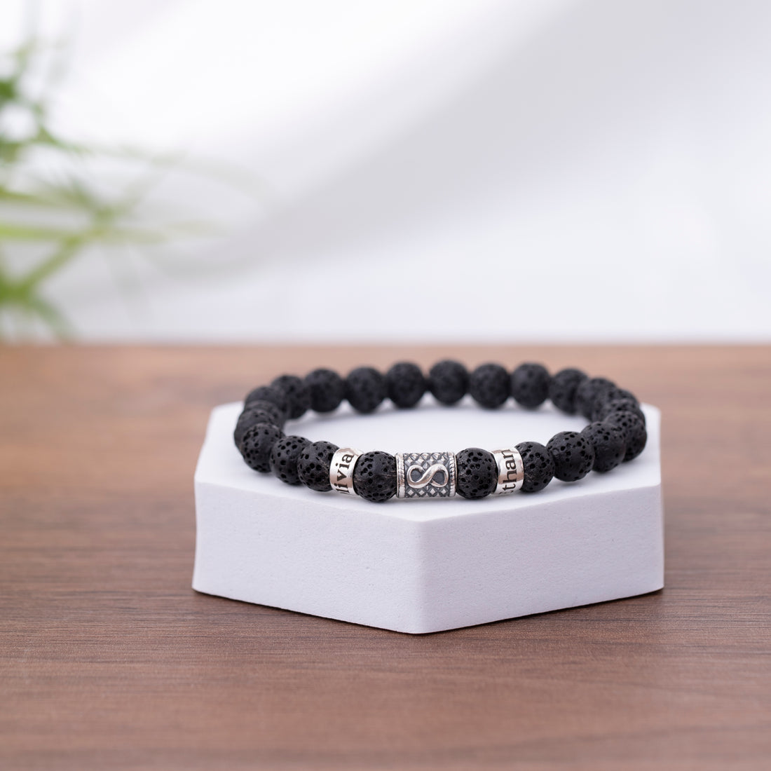 A sophisticated lava stone bracelet designed for men, adorned with an infinity charm and a personalized name tag, making it a thoughtful gift for dads.